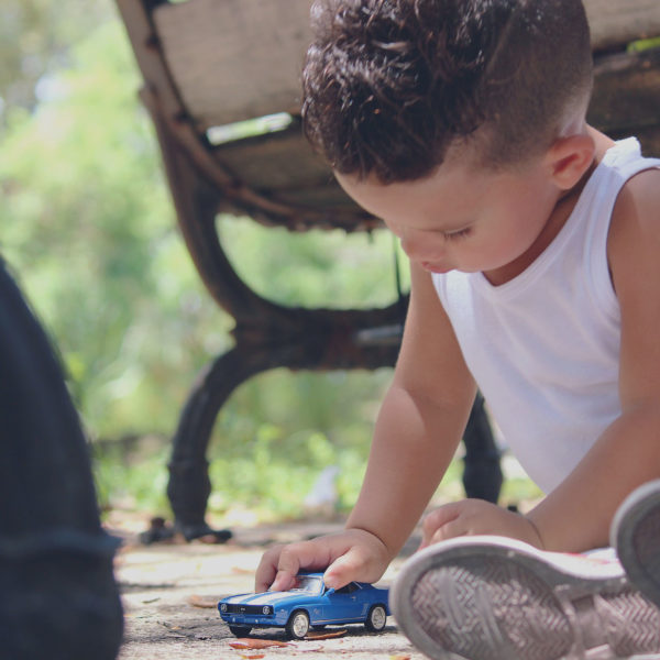 kleiner Junge spielt mit einem Spielzeugauto